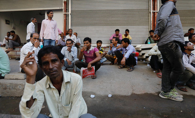 Tradespeople sit on the side of a road as they wait to get hired for work in Mumbai, India, November 6, 2017. REUTERS/Danish Siddiqui